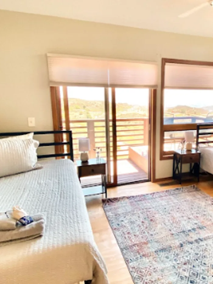 Bedroom with two beds and a balcony outlook